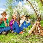 Three children resting near the wooden bonfire Three children resting near the wooden bonfire
