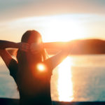 94363434 - happy hopeful woman looking at the sunset by the sea