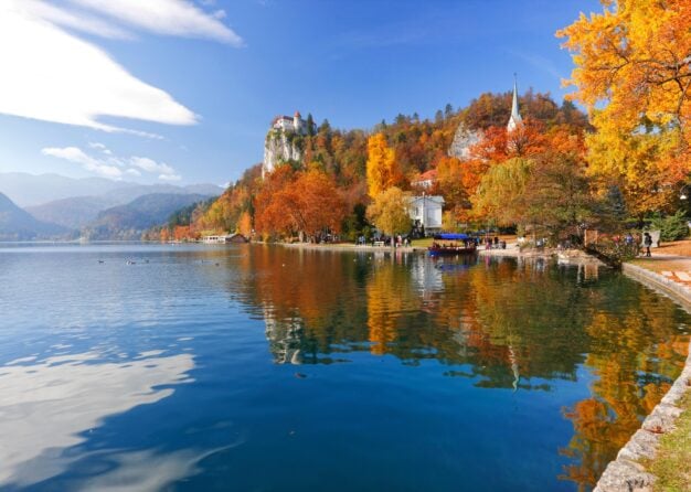 Destinația europeană care capătă un farmec aparte toamna. Un lac de poveste, păduri arămii și un castel pe stâncă